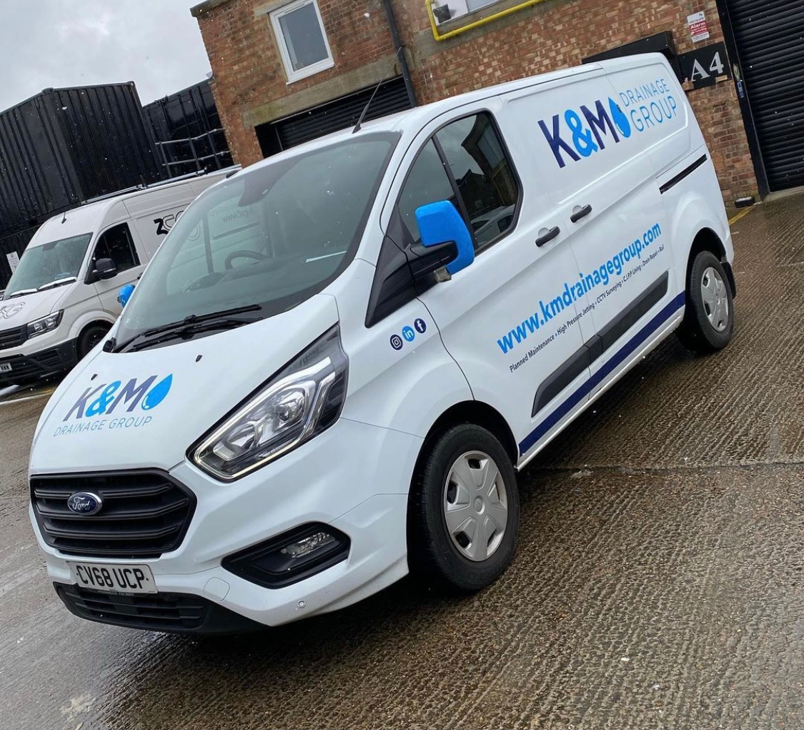 K&M Drainage Ford Custom van with company branding